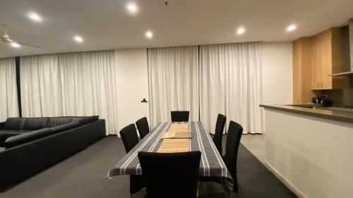 Solaire Apartments في غولد كوست: غرفة طعام مع طاولة وكراسي وأريكة