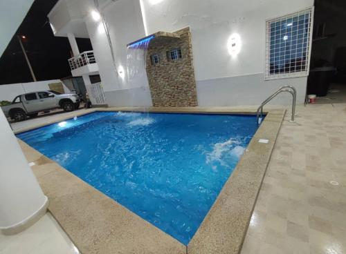 a large swimming pool in a room with a building at Hostería Luz Del Mar in Tonsupa