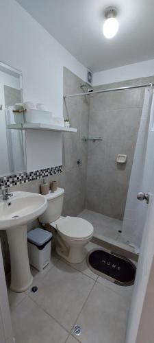y baño con aseo, lavabo y ducha. en Moderno departamento de 03 habitaciones en Lima