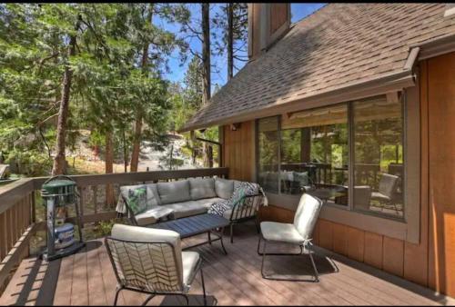 a patio with a couch and chairs on a deck at Arrowhead Lake Cabin pool table stunning views in Lake Arrowhead