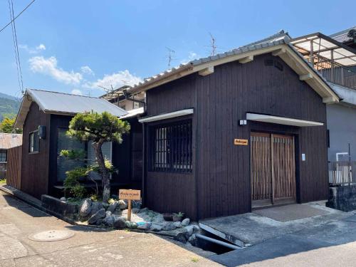 un edificio marrone con un cartello di fronte di Asuka no yado-明日香の宿- ad Asuka