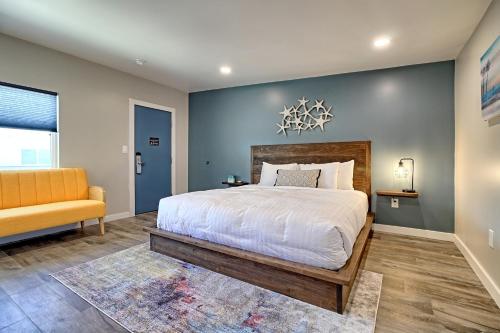 a bedroom with a large bed and a yellow couch at White Caps Motel in Ventura