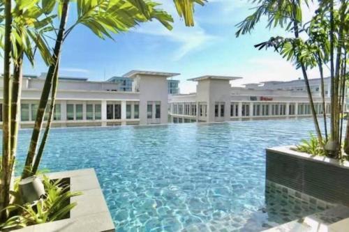 uma piscina em frente a um edifício com palmeiras em Seaview Sunrise Suite Imago Loft D 3 bedrooms 1600 sqft above Imago Shopping Mall em Kota Kinabalu