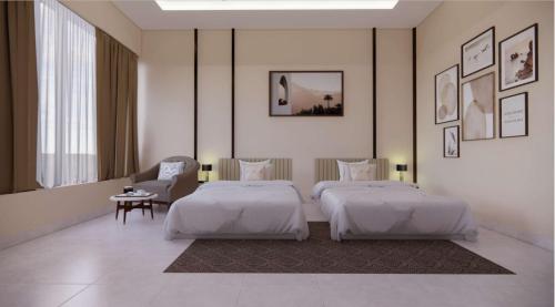 Pokój hotelowy z 2 łóżkami i krzesłem w obiekcie Vrishi Inn w mieście Bengaluru