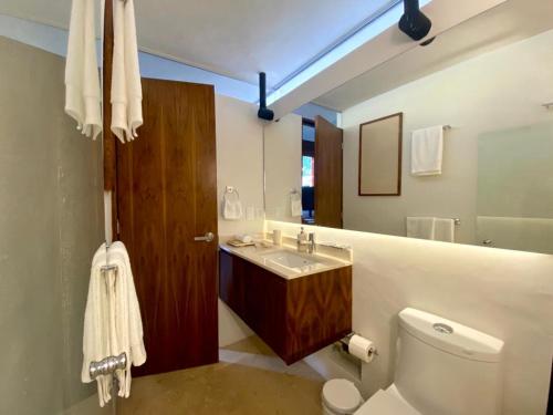 a bathroom with a sink and a toilet and a mirror at Las Lupitas Hotel Boutique in Campeche