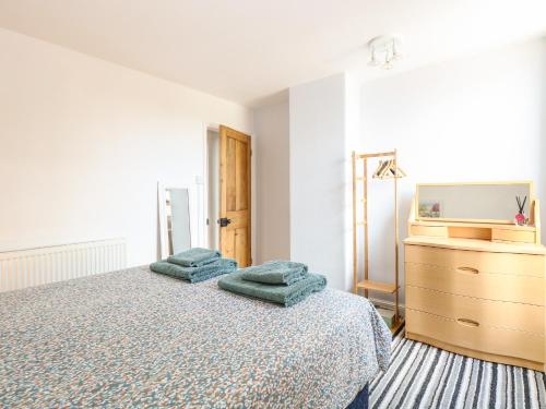 1 dormitorio con 1 cama con 2 almohadas verdes en Sole Bay Cottage en Lowestoft