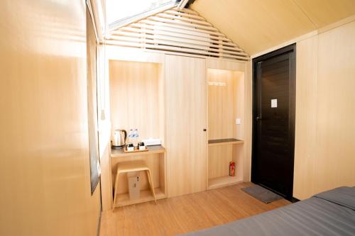 a bedroom with a bed and a desk and a window at Bobocabin Umarato, Sumba in Waikabubak