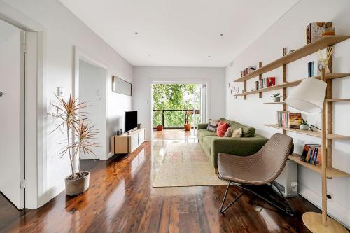 a living room with a green couch and a table at 'Bronte Beauty' Modern Heritage Style with Balcony in Sydney