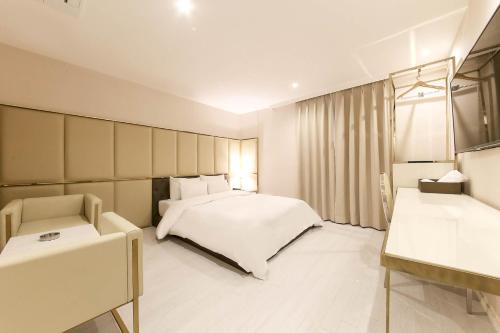a bedroom with a white bed and a chair and a window at Hotel Star Premier Yeoksam in Seoul