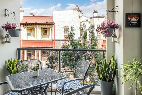 a balcony with a table and chairs and a view of a building at Charming Chippendale Escape with Rooftop Pool in Sydney