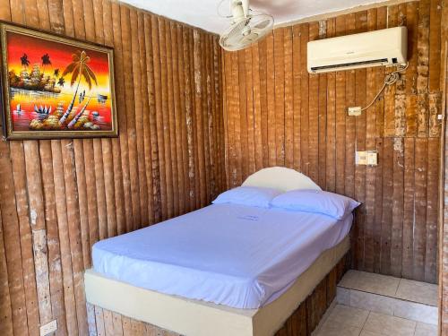 een slaapkamer met een bed in een houten muur bij SamHotels in Salado