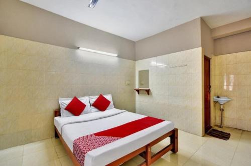 a bedroom with a bed with red pillows at RK RESIDENCY INN in Chennai