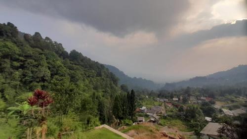 a view of a village in a mountain valley at Paseban Mountain View Camping Ground in Pondok Cipaseban