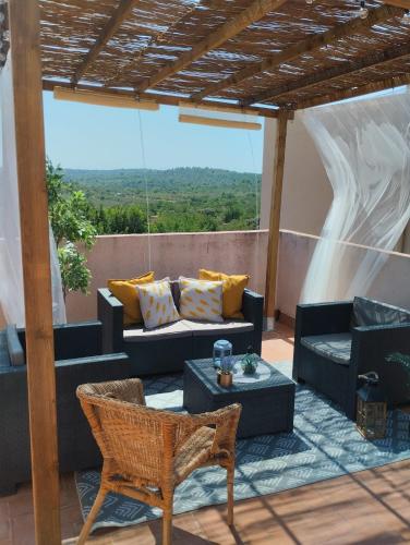 a patio with couches and a table and chairs at EL LLIMONER in Sant Jordi