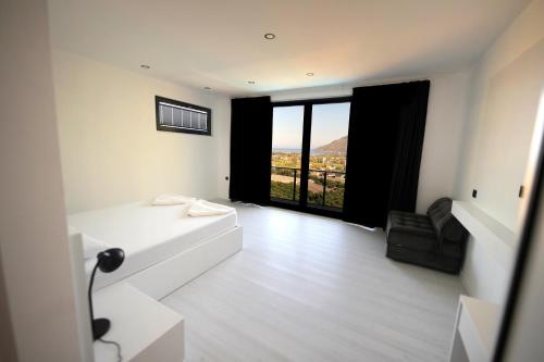 sala de estar con sofá blanco y ventana grande en Sun Rise Adrasan Villaları en Kumluca
