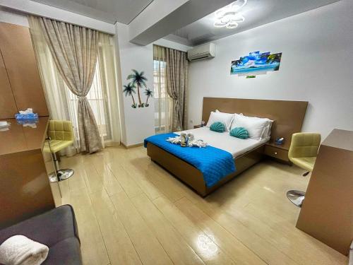 a bedroom with a bed with blue sheets and a room at Mamaia Nord-Astoria Lake-Studio in Mamaia