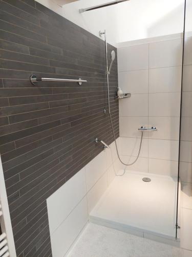 La salle de bains est pourvue d'une douche avec une porte en verre. dans l'établissement La chambre et le studio du château du golf de Bernalmont, à Liège