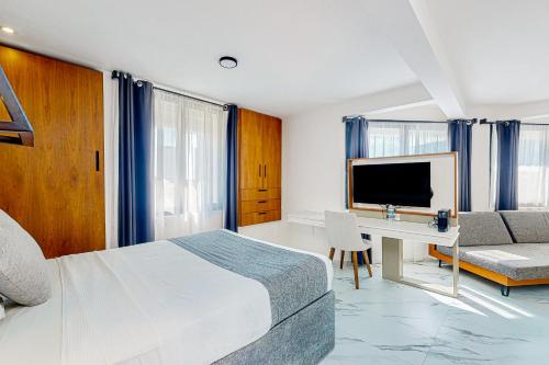 Un dormitorio con una cama, un escritorio y un televisor. en Seven Boutique 25, en Cancún