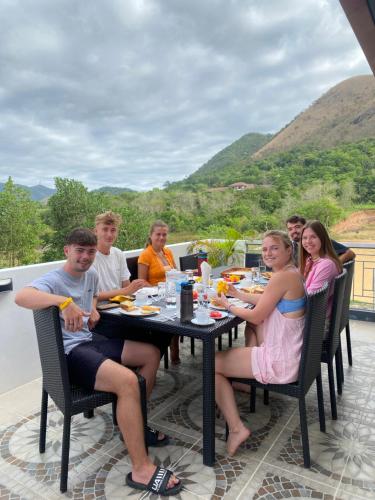 a group of people sitting at a table eating food at Bella Villa Coron in Coron