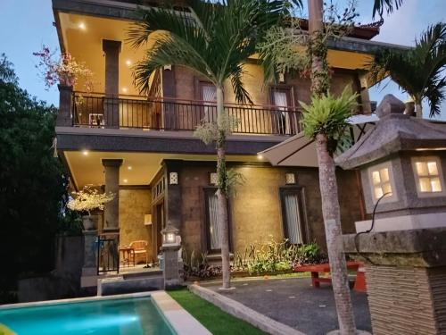 a house with a swimming pool in front of it at Ketut Kasta Guest House in Ubud