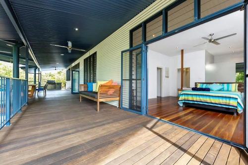 - un salon avec un canapé et un lit sur une terrasse dans l'établissement Golden Sands Retreat Beach House, à Wagait Beach