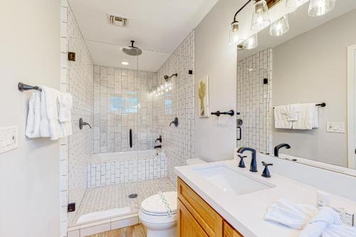 uma casa de banho branca com um lavatório e um chuveiro em Pink Door Place em Phoenix