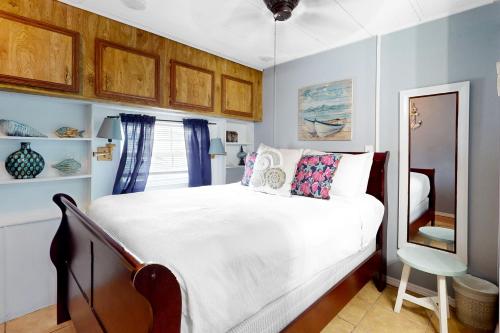 a bedroom with a white bed and a chair at Oyster Drive Bungalow in Port Isabel