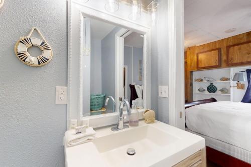 a bathroom with a sink and a mirror and a bed at Oyster Drive Bungalow in Port Isabel