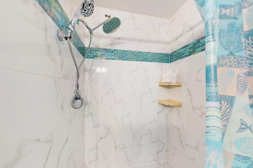 a bathroom with a shower with blue and white tiles at Oyster Drive Bungalow in Port Isabel