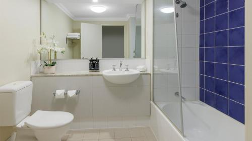 a bathroom with a toilet and a sink and a shower at Oaks Perth Hotel in Perth