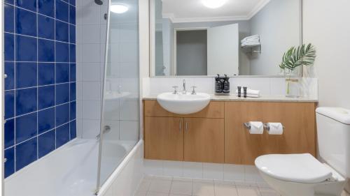 a bathroom with a sink and a tub and a toilet at Oaks Perth Hotel in Perth