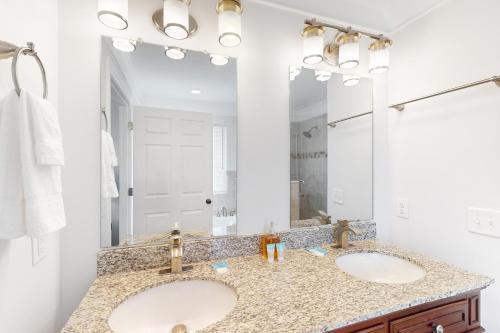 a bathroom with two sinks and a large mirror at Sunsets & Sunrises in Panama City Beach