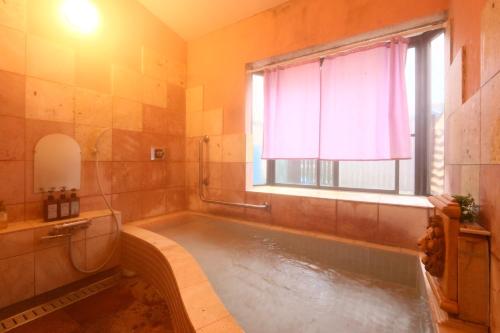 a bathroom with a large tub with a window at Naughty Cao in Yamanakako