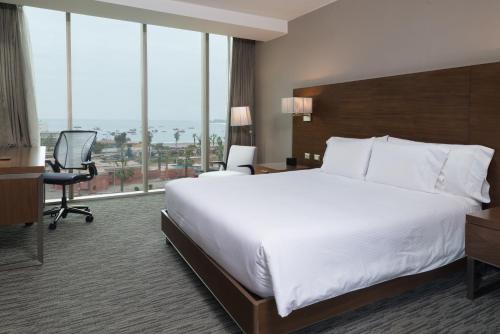 a hotel room with a large bed and a desk at Hilton Garden Inn Iquique in Iquique