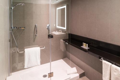 a bathroom with a shower and a tub and a sink at Hilton Garden Inn Iquique in Iquique