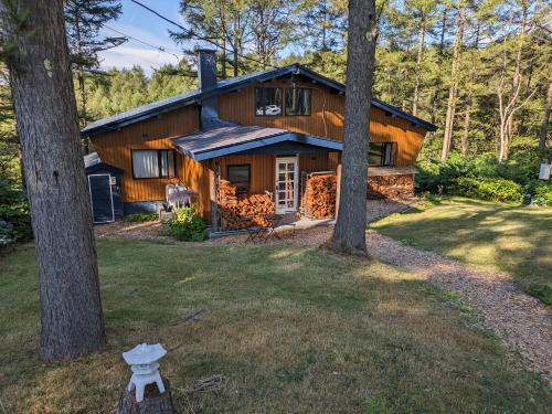 a log cabin in the woods with trees at Japan Snowsports in Iiyama