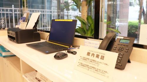 a desk with a laptop computer and a telephone at Toyoko Inn Tokyo Minami-machida in Machida