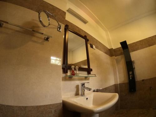Mount Seven Holiday Inn في بيلهول اويا: حمام مع حوض ومرآة