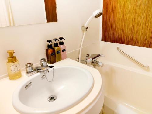 a bathroom with a sink and a toilet and a mirror at the b nagoya in Nagoya