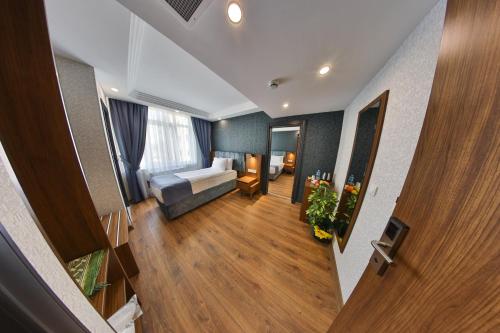 um quarto de hotel com uma cama e uma sala de estar em BUKAVİYYE HOTEL em Ancara