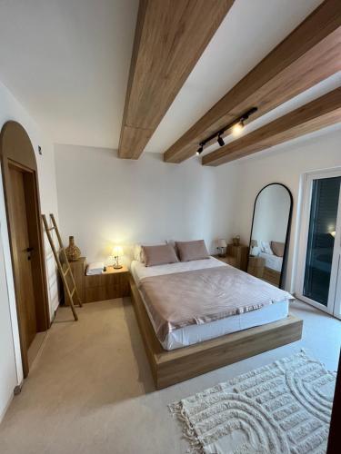 um quarto com uma cama grande e um espelho em Casa Brilla em Tivat