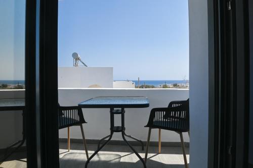 un tavolo e sedie su un balcone con vista sull'oceano di Villa Eleana a Monolithos