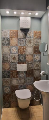 a bathroom with a toilet and a tiled wall at small miramare appartamento sogno sul mare in Trieste