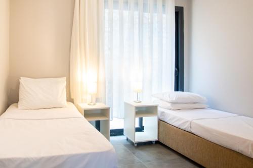 dwa łóżka w pokoju z dwoma lampami na stołach w obiekcie Sea View Flat with Shared Pool 5 min to Beach w mieście Akbük