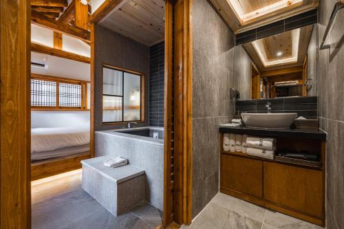a bathroom with a sink and a tub and a bed at Luxury hanok with private bathtub - SN05 in Seoul