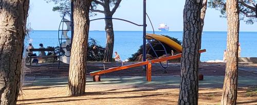 a playground with a slide and the ocean in the background at small miramare appartamento sogno sul mare in Trieste