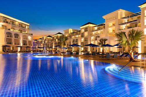 a large swimming pool in front of a hotel at Pickalbatros Blu Spa Resort - Adults Friendly 16 Years Plus- Ultra All-Inclusive in Hurghada