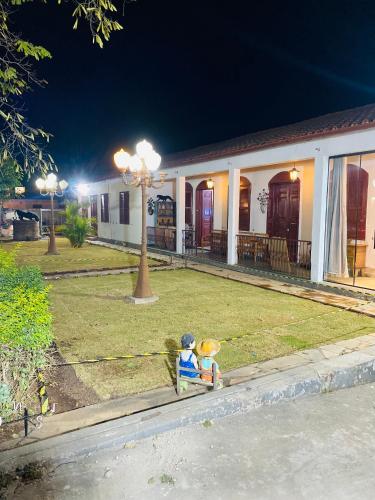two teddy bears sitting on a bench in front of a building at POUSADA CHARLOTTE in Tiradentes
