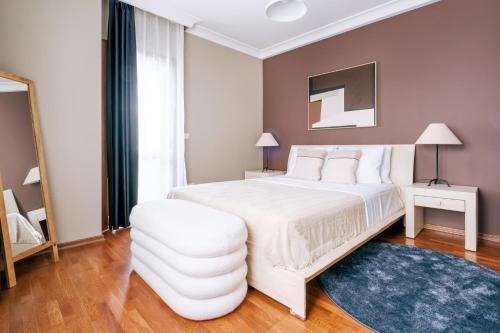 1 dormitorio con cama blanca y alfombra azul en Stylish Retreat w Balcony 2 min to Bagdat Ave, en Estambul