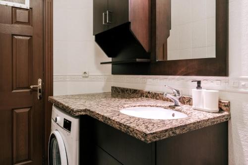 a bathroom with a sink and a washing machine at Stylish Retreat w Balcony 2 min to Bagdat Ave in Istanbul